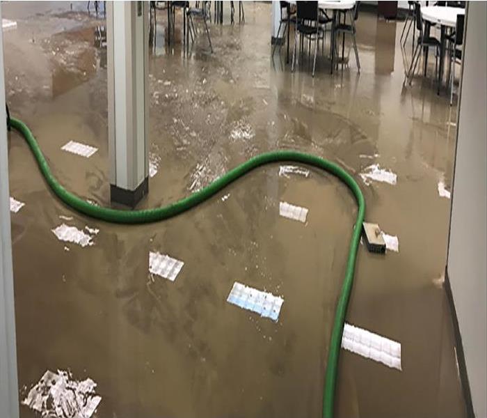 dirty standing water on the laminate tile floor of large cafeteria