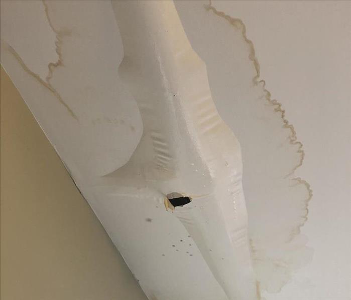 water damage on ceiling, paint bubbling and popped with water flowing out